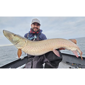 Picture of Musky Angler on a boat holding a Musky in his hands and wearing an EZOKO Logo Hoodie