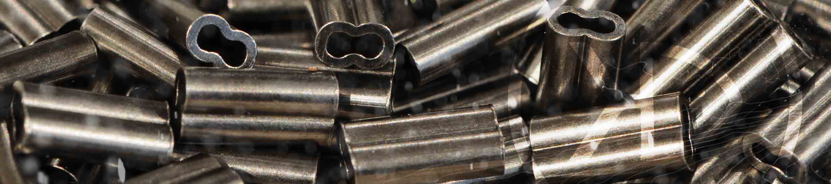 Lots of Double barrel copper sleeves lying on a table
